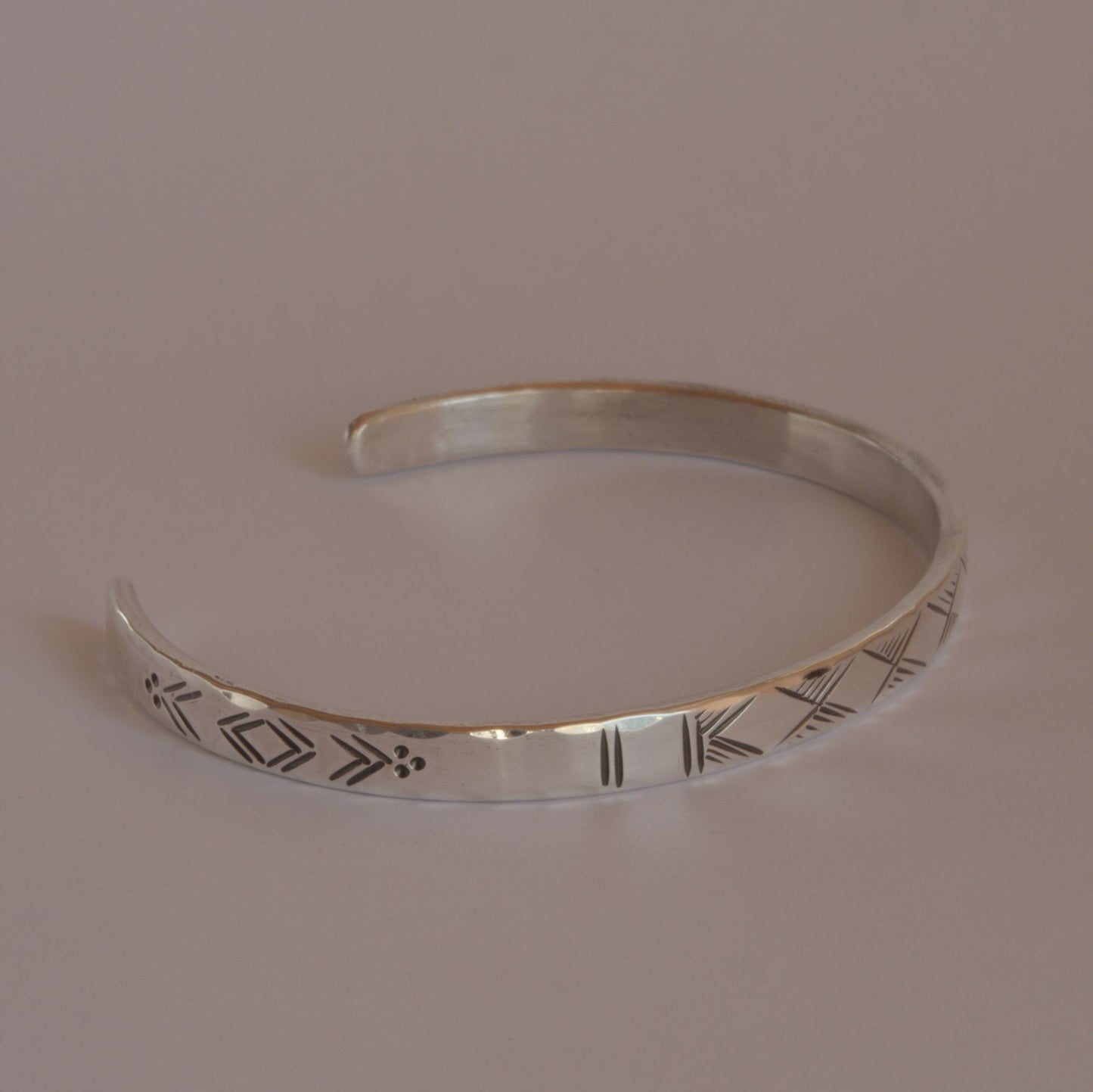 hammered silver bracelet with engraved motifs 